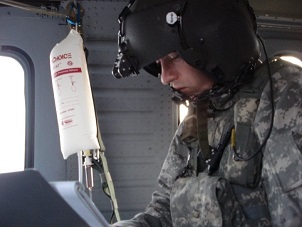 Kevin working on patient in helicopter, Iraq